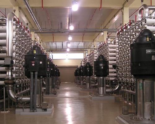 Interior photo of the 40-MGD, state-of-the-art membrane softening process. Fluid pumps and metal piping fill the room.